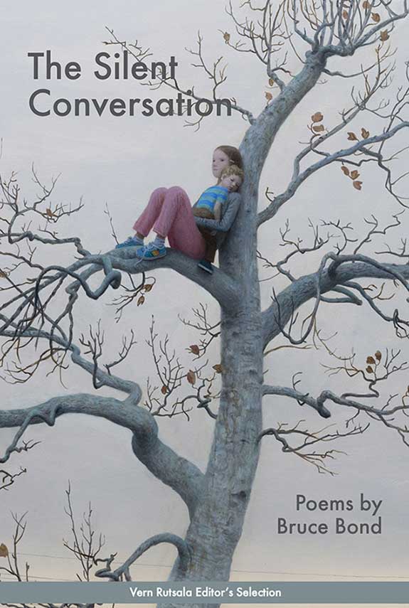 Girl in a tree holding a baby doll